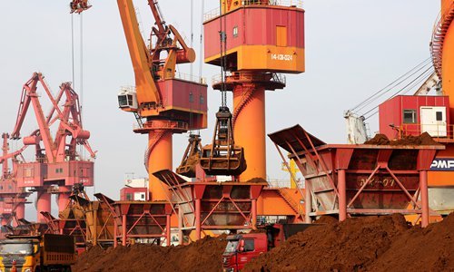 Jeřáby vykládají dovezenou železnou rudu ve východočínském přístavu Lianyuagang v provincii Jiangsu. V září přesáhla vykládka železné rudy v tomto přístavu 6,5 milionu tun, což z něj učinilo hlavní importní přístav pro dovoz železné rudy v Číně. Photo: VCG