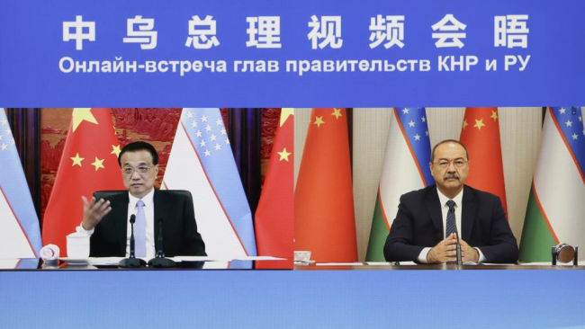 Čínský Premiér Li Keqiang (vlevo) pořádá rozhovor se svým uzbeckým protějškem Abdullou Aripovem přes video v Pekingu, hlavním městě Číny; 8. června 2021. / Xinhua