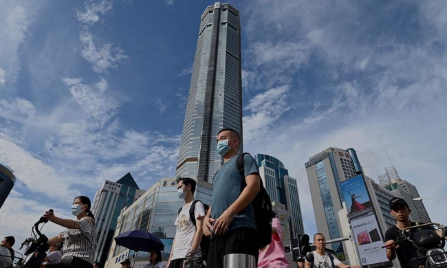 Lidé se prochází kolem dočasně zavřené 300metrové budovy SEG Plaza v čínském uzlu špičkových technologií Shenzhen v jihočínské provincii Guangdon, 24. května 2021. Photo: CFP