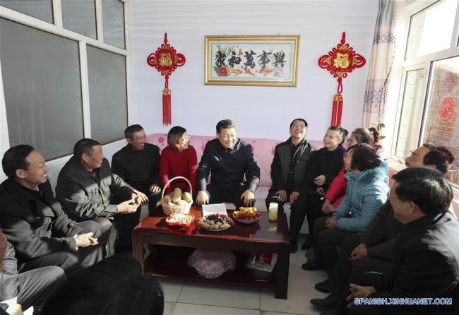 Xi Jinping conversa con aldeanos y cuadros locales en la vivienda del aldeano Xu Haicheng, en la aldea de Desheng, municipio de Xiaoertai del distrito de Zhangbei, provincia de Hebei, en el norte de China, el 24 de enero de 2017. (Xinhua/Lan Hongguang)