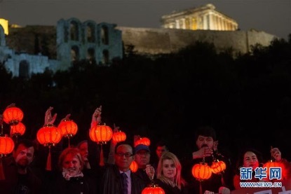 En la noche del 14 de febrero, las personas con linternas rojas al pie de la Acrópolis de Atenas participaron en una actividad en solidaridad con el pueblo chino en la lucha contra la epidemia. (Xinhua/Marios Lolos)