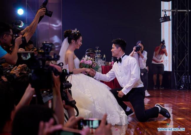 L'athlète chinois Su Bingtian et son épouse dans leur cérémonie de mariage au bourg de Guzhen de la ville de Zhongshan, dans la province du Guangdong, le 10 octobre 2017. (Xinhua/Liu Dawei)