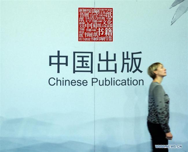 Une femme passe devant un panneau du pavillon chinois de la 69e Foire du livre de Francfort, en Allemagne, le 11 octobre 2017.
