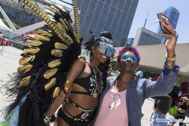 Cérémonie de lancement officiel du Carnaval caribéen 2018 sur la place Nathan Philips à Toronto, au Canada, le 10 juillet 2018. Comme le plus grand festival de son genre en Amérique du Nord, l'explosion culturelle annuelle de la musique locale, de la cuisine, des réjouissances, ainsi que des arts visuels et scéniques a commencé mardi à Toronto. (Xinhua/Zou Zheng)