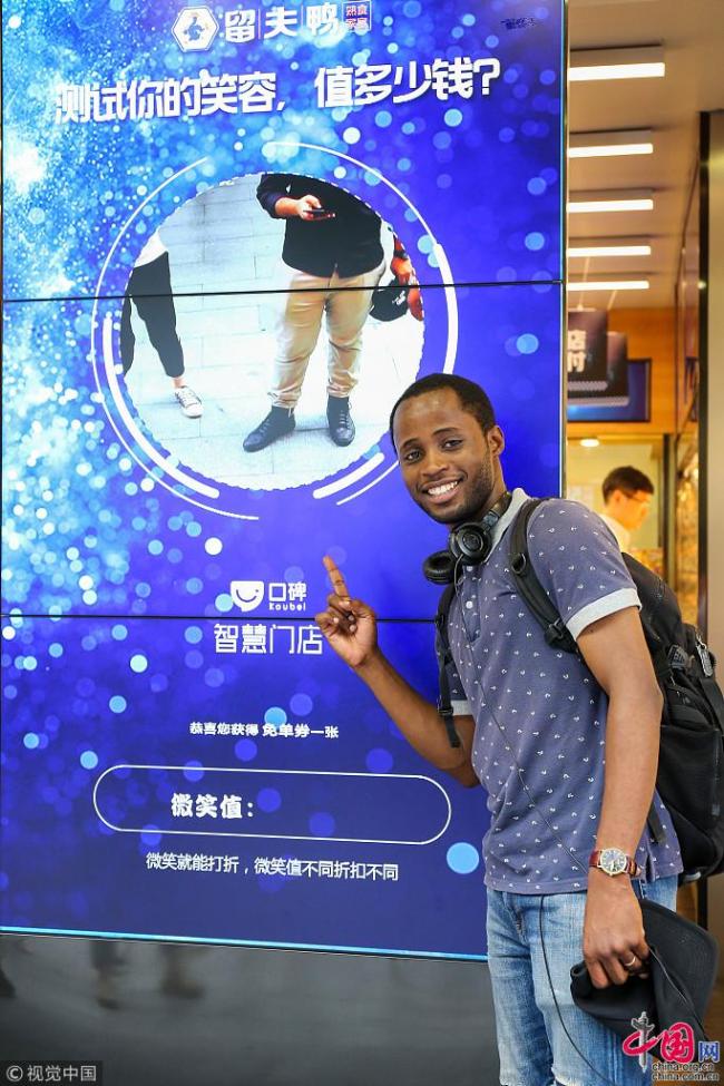Le jeune Congolais, aspirant chercheur à la faculté de cinématographie de l’Université normale du Jiangsu, pose à l’entrée du magasin.