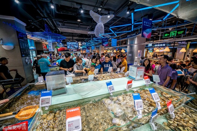 Des consommateurs achètent des fruits de mer chez Hema Fresh, à Guangzhou, capitale de la province du Guangdong. (Photo ：VCG)
