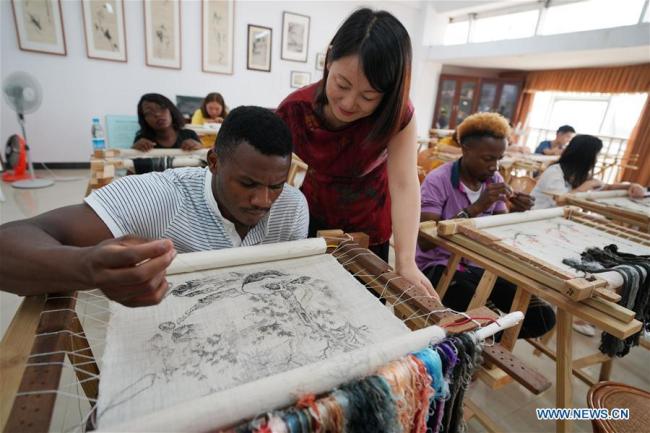 Un étudiant africain apprend la broderie sous la direction de Fu Aixiang, une enseignante de l’Université de Xinyu, à Xinyu, dans la province du Jiangxi (est de la Chine), le 5 septembre 2018. Avec le début du nouveau semestre, l’Université de Xinyu a mis en place des cours de broderie et d’arts martiaux pour permettre aux étudiants africains de mieux connaître la culture chinoise.
