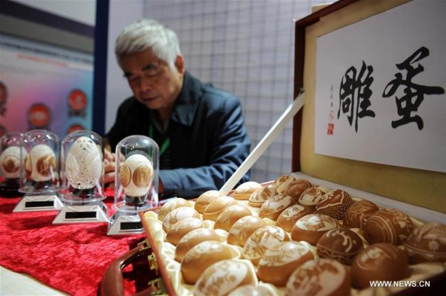 Un artisan expose des sculptures d'oeufs lors du Salon international de l'artisanat folklorique et des produits culturels de Chine (Guizhou) 2018, à Guiyang, dans la province chinoise du Guizhou (sud-ouest), le 23 novembre 2018. Plus de 200 artisans ont présenté leurs compétences et leurs produits traditionnels à l'occasion du salon du patrimoine culturel intangible qui s'est ouvert vendredi à Guiyang. (Photo : Yang Wenbin)
