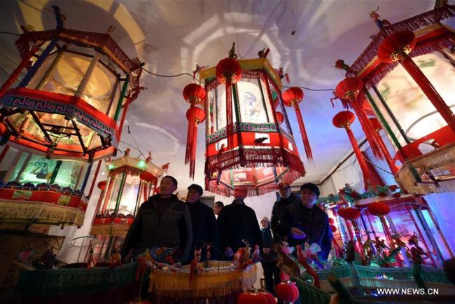 Des commerçants regardent des zootropes lumineux, dans le village de Wangqiao du bourg de Gangshang, dans le district de Tancheng de la ville de Linyi, dans la province chinoise du Shandong (est), le 11 janvier 2019. Cette sorte de lanterne traditionnelle chinoise projette des images en rotation et donne l'illusion d'un mouvement continu. Selon la tradition locale, les habitants fabriquent ces lanternes pour célébrer le Nouvel An lunaire chinois. (Photo : Fang Dehua)