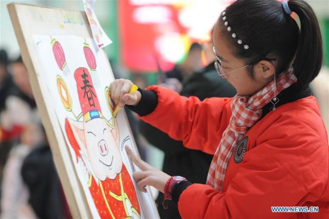 Une enfant dessine pour célébrer la prochaine fête du Printemps à Yantai, dans la province du Shandong (est de la Chine), le 26 janvier 2019.