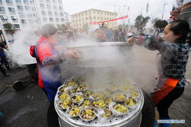 Des gens préparent à manger pour les habitants d'une communauté de réduction de la pauvreté à l'approche de la fête du Printemps, dans le district de Huishui de la préfecture autonome Buyi et Miao de Qiannan, dans la province chinoise du Guizhou (sud-ouest), le 31 janvier 2019. (Photo : Zhang Hui)