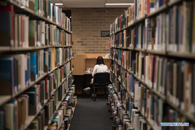 Une femme lit dans une bibliothèque à Canberra, en Australie, le 22 avril 2019. La Journée mondiale du livre et du droit d'auteur est un événement annuel célébré le 23 avril pour promouvoir la lecture, la publication et les droits d'auteur. (Xinhua/Liu Changchang)