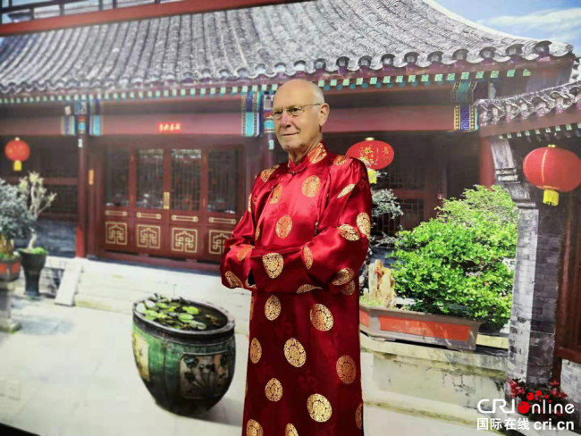 Kurt Karst, président de la Fédération de l’Association de l’amitié sino-allemande, essaie les costumes de l’opéra dans le quartier de Ganjiakou