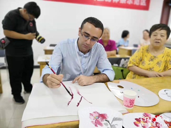 Masum Gök, journaliste turc du magazine Modern Silk Road, apprend la peinture chinoise dans le quartier de Ganjiakou