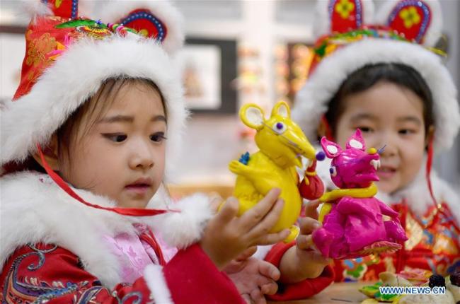 Des enfants regardent des « petits pains fleuris » traditionnels lors d'une activité d'art populaire de la fête du Printemps qui a eu lieu à Xi'an, capitale de la province du Shaanxi (nord-ouest de la Chine), le 10 janvier 2020. Une activité sur le thème des « petits pains fleuris » a eu lieu ici vendredi pour promouvoir l'art populaire dans la partie centrale de la province du Shaanxi à l'approche de la Fête du Printemps. (Liu Xiao / Xinhua)