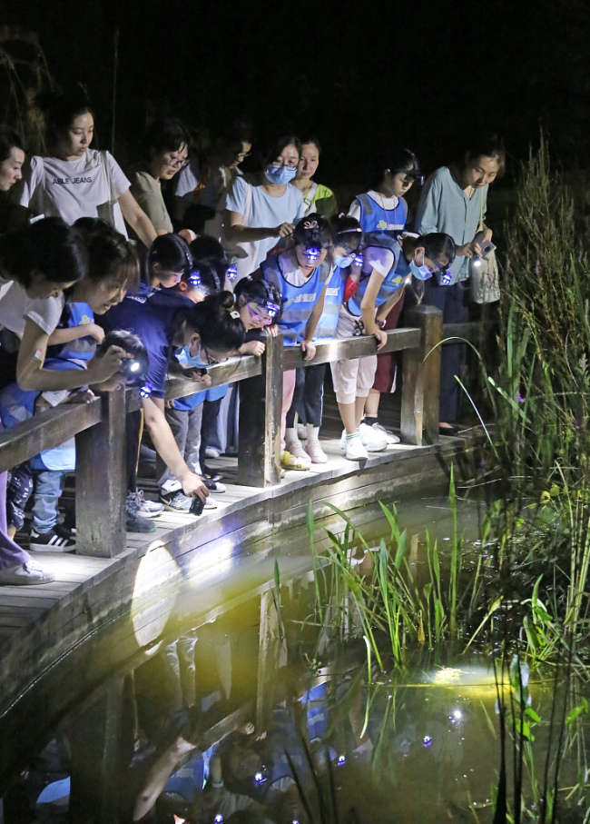 Les visiteurs participent à une visite nocturne organisée pour promouvoir les connaissances botaniques au Jardin botanique Chenshan de Shanghai, à Shanghai, dans l'est de la Chine, le 7 août 2020.