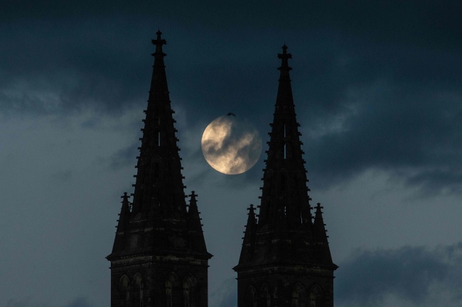 La super lune se lève derrière l’église Saint-Pierre-et-Saint-Paul, le 25 mai, à Prague, en Tchéquie.
