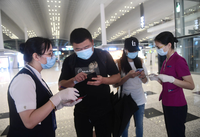 Des voyageurs en train de scanner leur code QR de santé, à l’entrée de la Gare du Sud le 31 mai, à Guangzhou, dans la province du Guangdong.