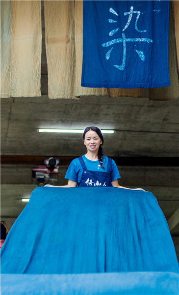 Η Γιανγκ απλώνει το παραδοσιακό βαμμένο πανί μπροστά από το εργαστήριό της. [Φωτογραφία από τον Fu Jianbin / Για την Κίνα καθημερινά] 