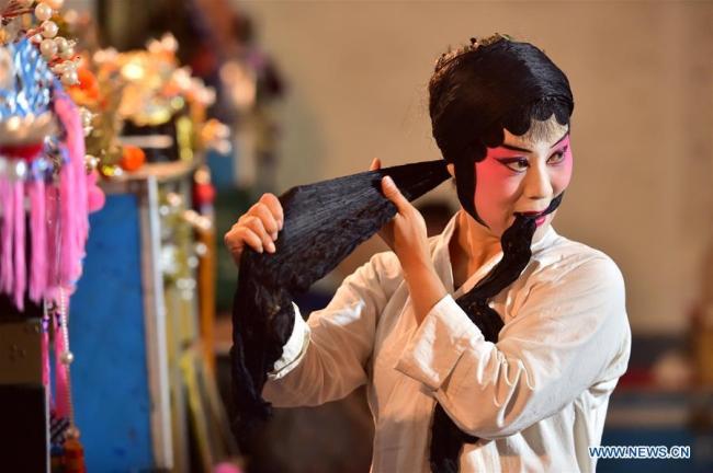 Μια ηθοποιός φτιάχνει τα μαλλιά της καθώς ετοιμάζεται για μια παράσταση όπερας του τοπικού θιάσου Τζιν στο χωριό Τοουτσουάν της κομητείας Τζινγκσίνγκ, στο Σιτζιατζουάνκ, πρωτεύουσα της επαρχίας Χεμπέι, 5 Αυγούστου 2020. (Photo by Zhang Xiaofeng/Xinhua)