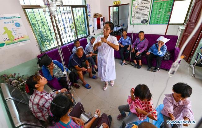 Η Λουό Μου πραγματοποιεί ενδοφλέβια στάγδην για τους χωρικούς στην κλινική στο χωριό Τσουιγουέι της κομητείας Λονγκλί, στην αυτόνομη περιφέρεια Τσιενάν Μπουγί-Μιάο στην επαρχία Γκουιτζόου της νοτιοδυτικής Κίνας, στις 19 Αυγούστου 2020.