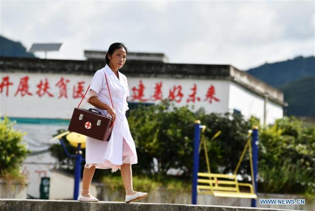 Η γιατρός ενώ πηγαίνει να επισκεφθεί έναν ασθενή στο χωριό Τσουιγουέι της κομητείας Λονγκλί, στην αυτόνομη περιφέρεια Τσιενάν Μπουγί-Μιάο στην επαρχία Γκουιτζόου της νοτιοδυτικής Κίνας, 18 Αυγούστου 2020.