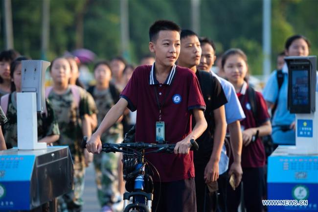 Μαθητές περιμένοντας στην σειρά για να μπουν στο γυμνάσιο Νταογού του Λιουγιάνγκ στην πόλη Τσανγκσά, πρωτεύουσα της επαρχίας Χουνάν στην κεντρική Κίνα, στις 31 Αυγούστου 2020. (φωτογραφία/ Xinhua)