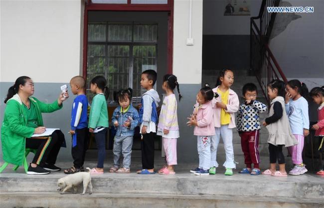 Η Παν Μινγκτζέν λαμβάνει τη θερμοκρασία των μαθητών στο Δημοτικό Σχολείο Μιαομπέν ως προφύλαξη για τον COVID-19 στο δήμο Τζονγκτσένγκ, στην κομητεία Ρονγκτζιάνγκ της επαρχίας Γκουιτζόου της νοτιοδυτικής Κίνας, στις 8 Σεπτεμβρίου 2020.6