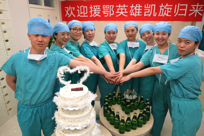 Η Τσούι Γουέι (δεύτερη από δεξιά) και οκτώ άλλες νοσοκόμες ποζάρουν για μια ομαδική φωτογραφία σε ένα πάρτι καλωσορίσματος για το ιατρικό προσωπικό που πήγε στην επαρχία Χουμπέι, στον αγώνα της χώρας κατά της πανδημίας COVID-19, στο Νοσοκομείο Φιλίας Κίνας-Ιαπωνίας στο Πεκίνο στις 7 Μαΐου. ZHU XINGXIN / CHINA ΚΑΘΗΜΕΡΙΝΑ<br>