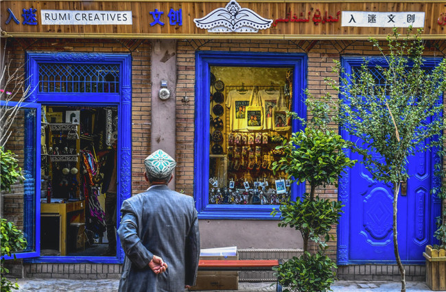 Ένας άντρας κοιτάζει το παράθυρο ενός καταστήματος πολιτιστικών και δημιουργικών προϊόντων στην Παλιά Πόλη. [Φωτογραφία / XINHUA]