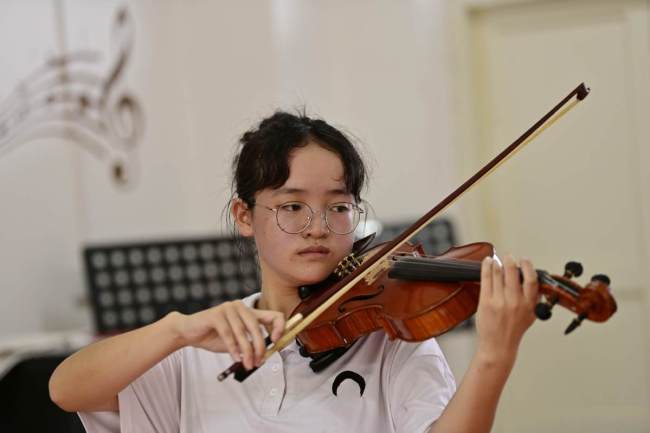 Μια μαθήτρια γυμνασίου από την κομητεία Τσονγκτζιάνγκ, στην επαρχία Γκουιτζόου της νοτιοδυτικής Κίνας, παίζει βιολί. [Φωτογραφία/ chinadaily]