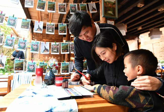 Ο Χου Γουενλιάνγκ (πρώτος αριστερά) φτιάχνει καρτ ποστάλ μαζί με την οικογένειά του. 