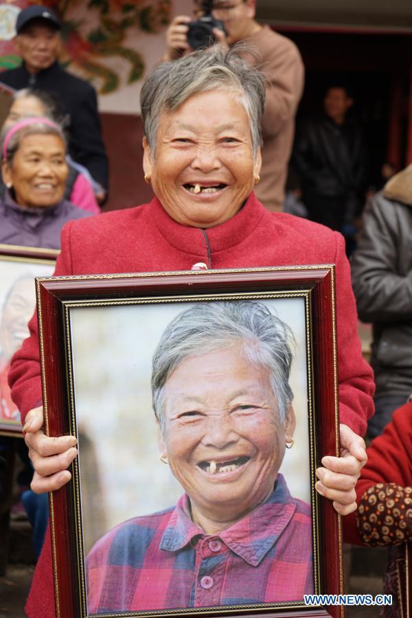 Χωρική χαμογελά καθώς κρατά το πορτραίτο της στο χωριό Σιαγουέι της περιοχής Γιοουλάν, κοντά στην πρωτεύουσα Ναντσάνγκ, στην επαρχία Τζιανγκσί της ανατολικής Κίνας, στις 22 Νοεμβρίου 2020.