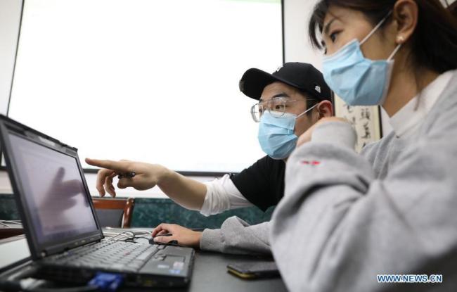 Προσωπικό του πανεπιστημίου ελέγχει τα στοιχεία των φοιτητών στο Πανεπιστήμιο Τεχνολογίας του Νταλιάν, στην επαρχία Λιαονίνγκ της βορειοανατολικής Κίνας στις 20 Ιανουαρίου 2021. 