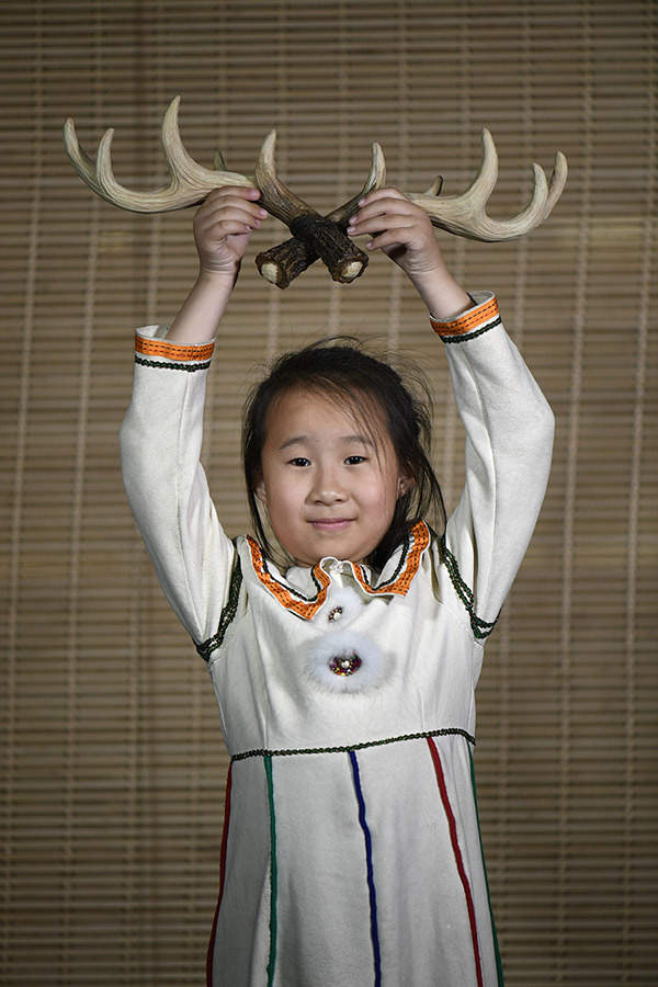 Η κόρη της Σουογιούν δείχνει ένα ζευγάρι κέρατα ταράνδων. [Φωτογραφία από WANG WEI / FOR CHINA DAILY]