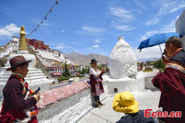 Τουρίστες βγάζουν φωτογραφίες στο βουνό Γιαογουάνγκ στην Λάσα, πρωτεύουσα της Αυτόνομης Περιοχής του Θιβέτ στην νοτιοδυτική Κίνα. (φωτογραφία: China News Service)
