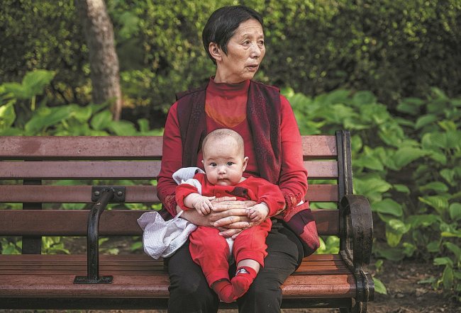 Një foshnjë qendroi me gjyshen e saj gjatë vizitës në një park në Pekin në majin e vjetshëm/Photo nga KEVIN FRAYER për "CHINA DAILY"