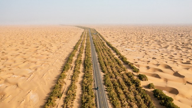 Foto/CFP: Autostrada në shkretëtirë e Tarimit, e cila përshkon shkretëtirën Taklimakan në Rajonin Autonom të Xinjiang-Ujgurit, arrin lëshimin zero të karbonit.