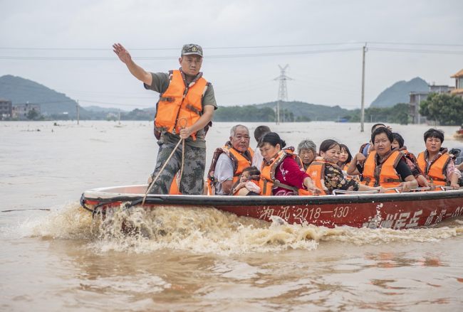 Kuadro partiakë ndihmonin banorët e fshatit Guangming të evakuuoheshin nga shtëpitë e përmbytura, provincë Hu'nan, 22 qershor 2022(Foto:VCG)