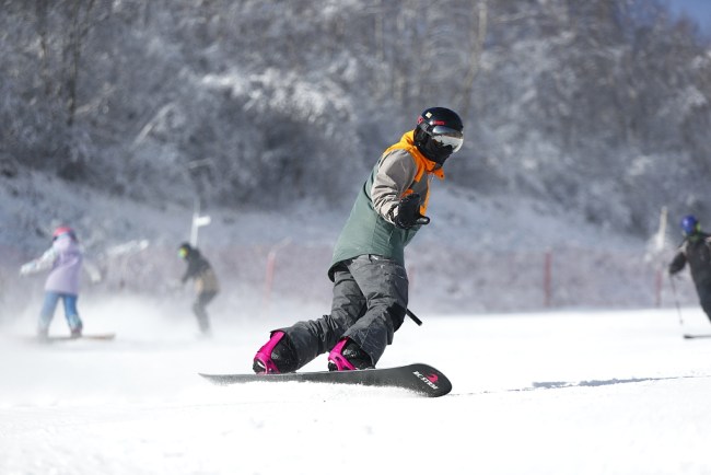Un skieur pratique le snowboard à Chongli, Zhangjiakou (Crédit:VCG)