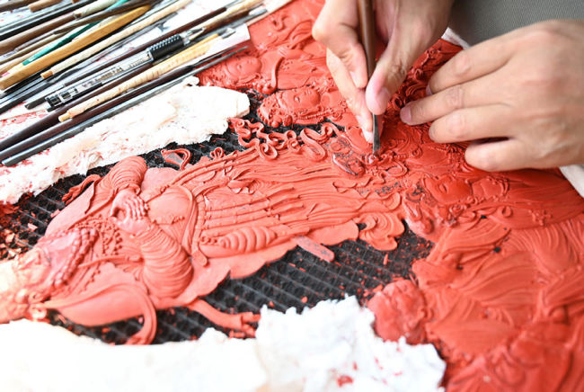 Ένας καλλιτέχνης του Ινστιτούτου Έρευνας Τέχνης της Λάκας Φουτζιέν Χονγκμέν χαράζει έργα λάκας στις 27 Ιουλίου. [Φωτογραφία/Xinhua
