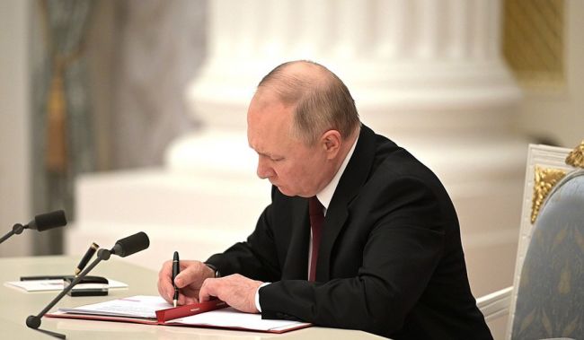 Ο Ρώσος Πρόεδρος Βλαντιμίρ Πούτιν υπογράφει έγγραφα που αναγνωρίζουν τις «Λαϊκές Δημοκρατίες του Ντόνετσκ και του Λουγκάνσκ» στο Κρεμλίνο στη Μόσχα στις 21 Φεβρουαρίου 2022. (Δελτίο τύπου του Κρεμλίνου)