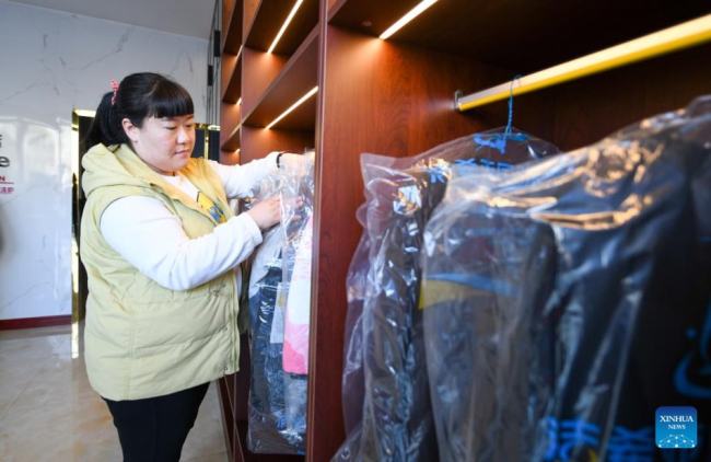 Η Τιεν Λιτσάο ενώ εργάζεται σε ένα κατάστημα στεγνού καθαρισμού για άτομα με ειδικές ανάγκες στην περιοχή Μπαοντί, στο Τιεντζίν της βόρειας Κίνας, 1 Μαρτίου 2022.