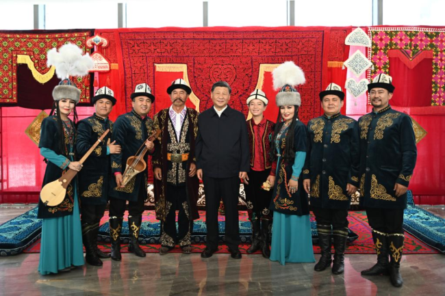 Ο Κινέζος Πρόεδρος Σι Τζινπίνγκ ποζάρει για φωτογραφίες με τους ερμηνευτές του Μανάς, το οποίο έχει εγγραφεί ως άυλη πολιτιστική κληρονομιά, ενώ επισκέπτεται το Μουσείο της Αυτόνομης Περιοχής Σιντζιάνγκ Ουιγούρ, στην πόλη Ουρούμτσι, πρωτεύουσα της Αυτόνομης Περιοχής Σιντζιάνγκ Ουιγούρ της βορειοδυτικής Κίνας, στις 12 Ιουλίου 2022. (φωτογραφία/Xinhua)
