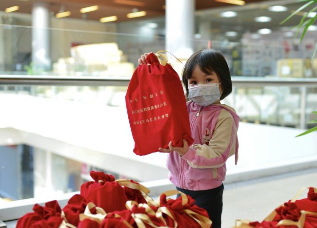 O fetiță a fost alături de pachete de materiale sanitare donate de Asociația Chineză de Prietenie cu Străinătatea, Biroul pentru Afacerile Emigranților Chinezi din Zhejiang și Ambasada Chinei în România.