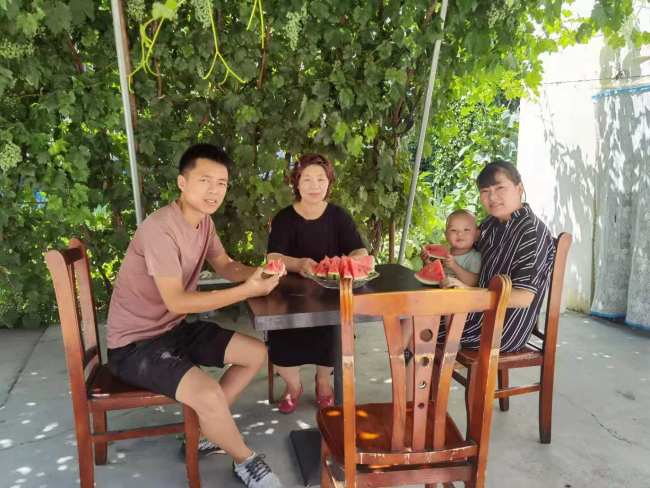 Foto 6: Teta Shang a rodina jejího syna si užívají chladu pod pergolou porostlou vínem na dvoře