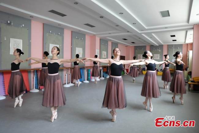 Μια ερασιτεχνική ομάδα ασκείται στο μπαλέτο σε ένα πολιτιστικό κέντρο στην περιοχή Τζινσούι, Τζενγκτζόου, επαρχία Χενάν της κεντρικής Κίνας, 7 Ιουλίου 2021. Οι γιαγιάδες της ομάδας, περίπου 60 χρονών κατά μέσο όρο η κάθε μία, ξεκινούν από το βασικό επίπεδο και ξεπερνούν σιγά σιγά όσο μπορούν τα φυσικά όρια στην επιδίωξη του ονείρου τους για αυτόν τον χορό. (Φωτογραφία: China News Service)