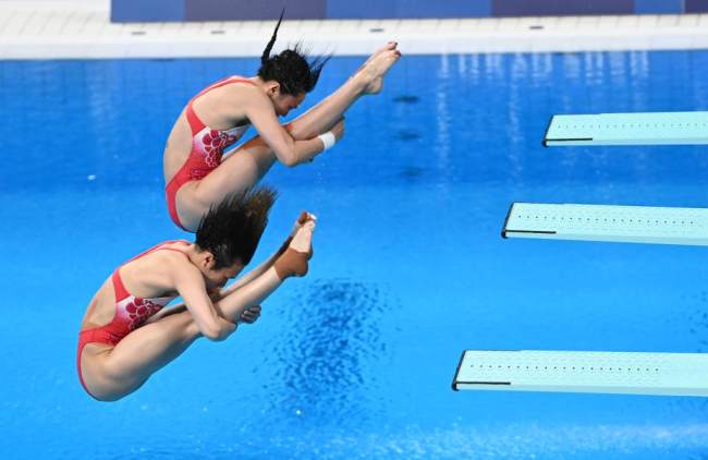Οι Κινέζες αθλήτριες Σι Τινγκμάο και Γουάνγκ Χαν κατά τον αγώνα της κατάδυσης από βατήρα 3 μ. γυναικών νταμπλ στους Ολυμπιακούς Αγώνες του Τόκιο στις 24 Ιουλίου 2021. (φωτογραφία / Xinhua)