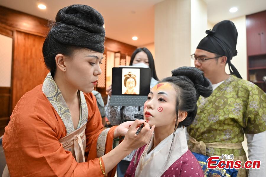 Μια μακιγιέζ ετοιμάζει ένα μέλος της ομάδας σε ένα εργαστήριο στο Νανίνγκ, στην Αυτόνομη Επαρχία Γκουανσί Τζουάνγκ στην νότια Κίνα, σε φωτογραφία από τις 9 Οκτωβρίου 2022.