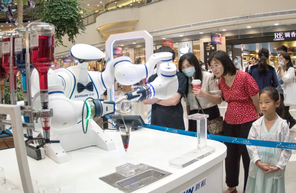 Vizitorët vëzhgojnë një robot duke bërë një koktej gjatë WAIC 2021 në Shangai. [Foto e dhënë për China Daily]